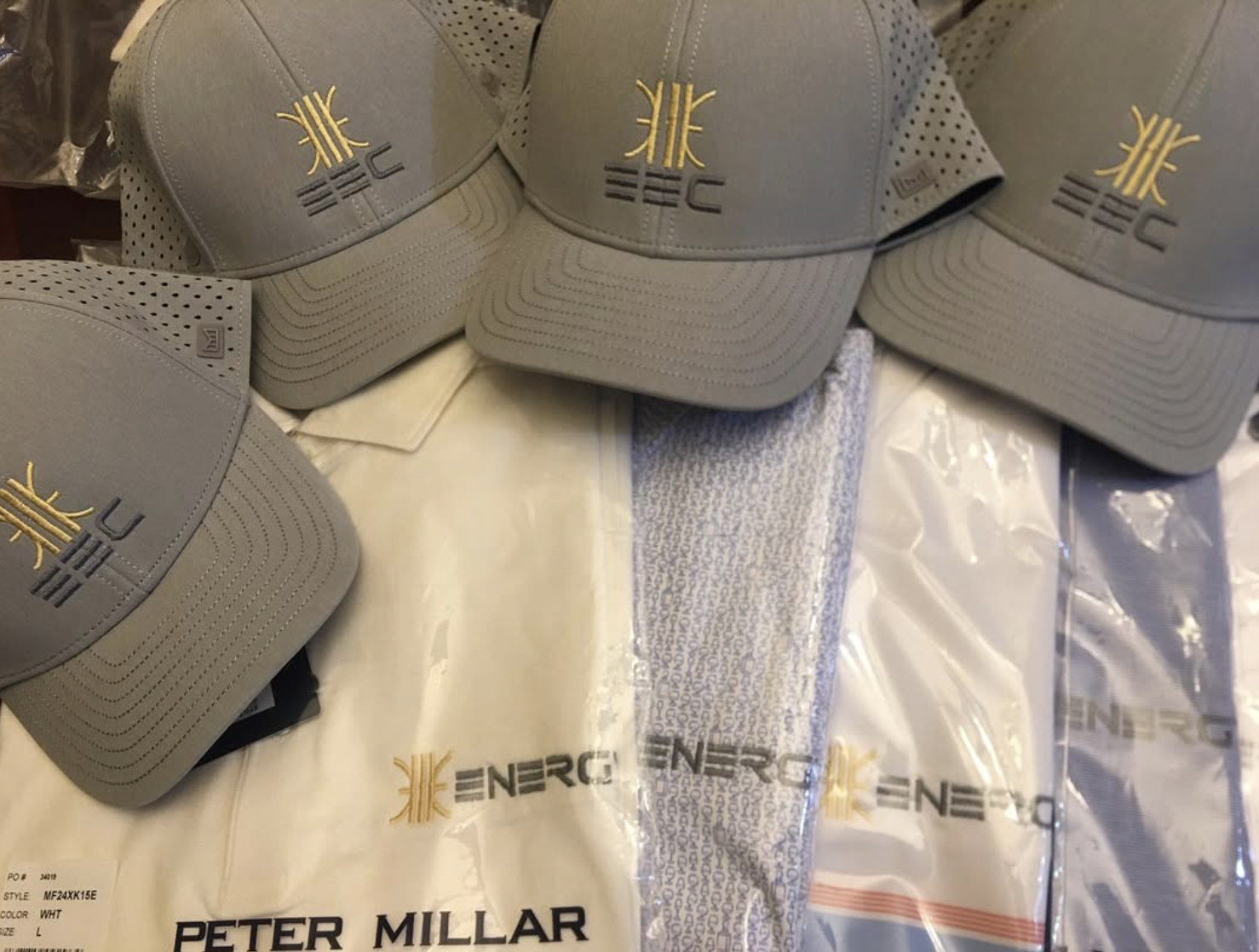 EEC crew gear — embroidered hats + Peter Millar polos.